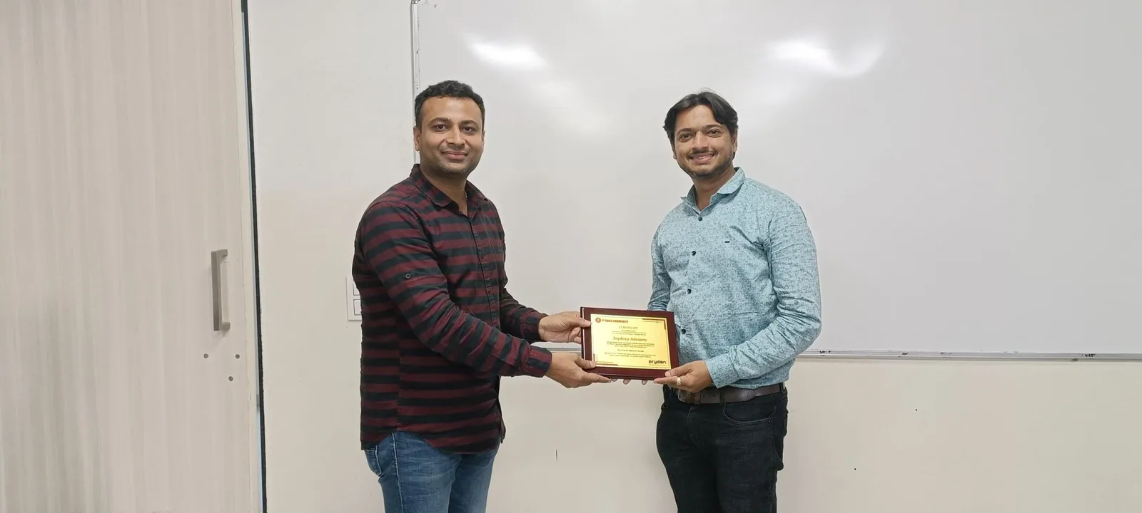 Jaydeep Adesara receiving a certificate after a speaking session